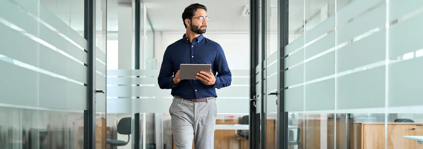 Business man wearing grey dress pants holding a tablet.