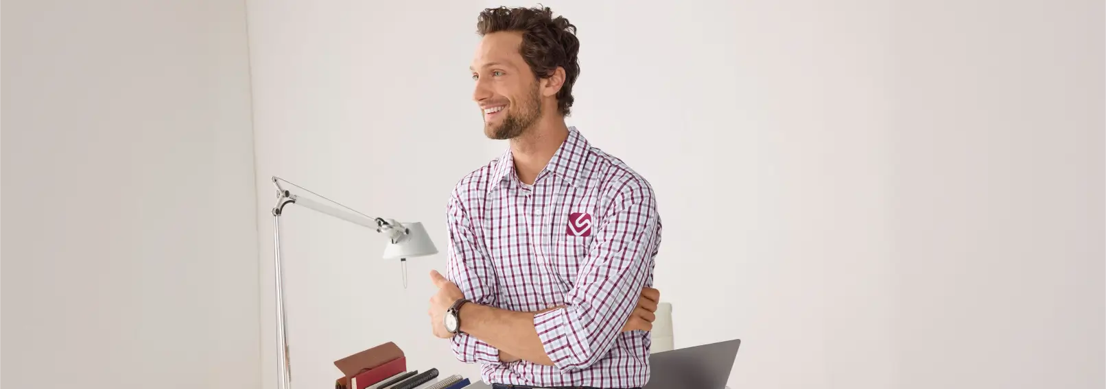 Man wearing a branded plaid button-down shirt as a summer business casual uniform.