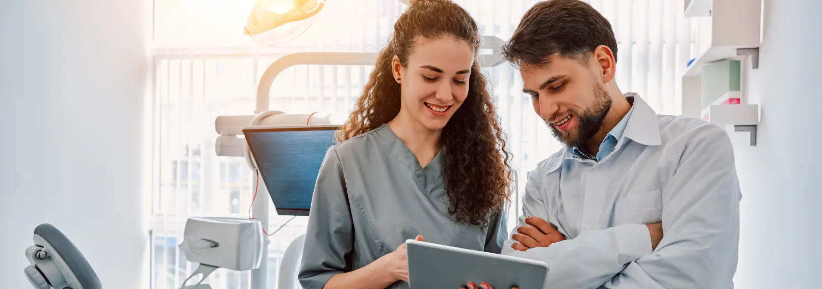 Dental hygienist consulting a dentist in a patent room.