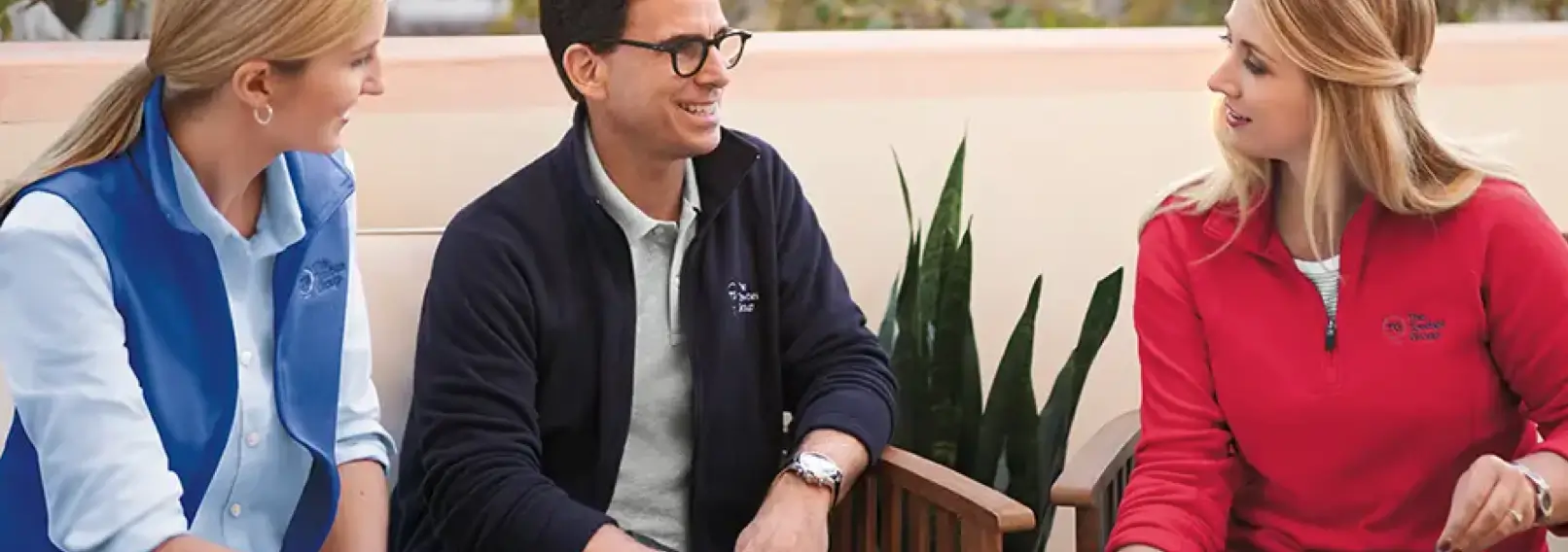 Coworkers in branded uniforms having a conversation