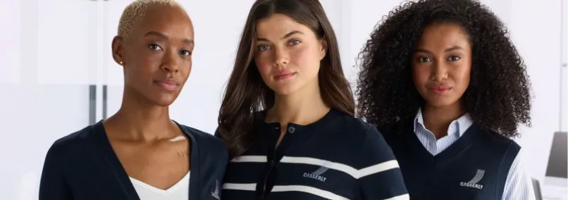 Three women wearing Casserly-branded navy corporate uniform sweaters and vests.