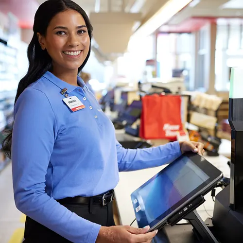A convenience store employee working a checkout station.
