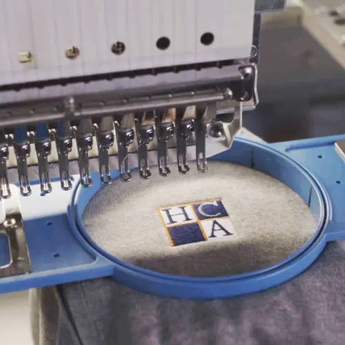 Embroidery machine stitching a brand logo onto apparel.