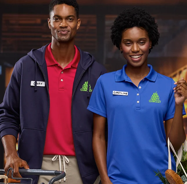 Two grocery store employees wearing monogrammed uniforms