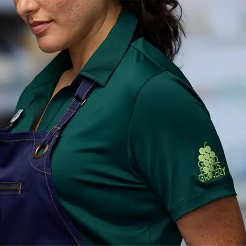 Left sleeve logo placement on a green collared short sleeve shirt.