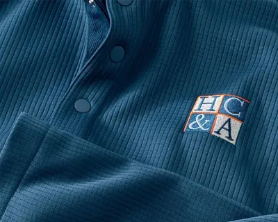 Blue snapneck pullover with custom logo embroidery.