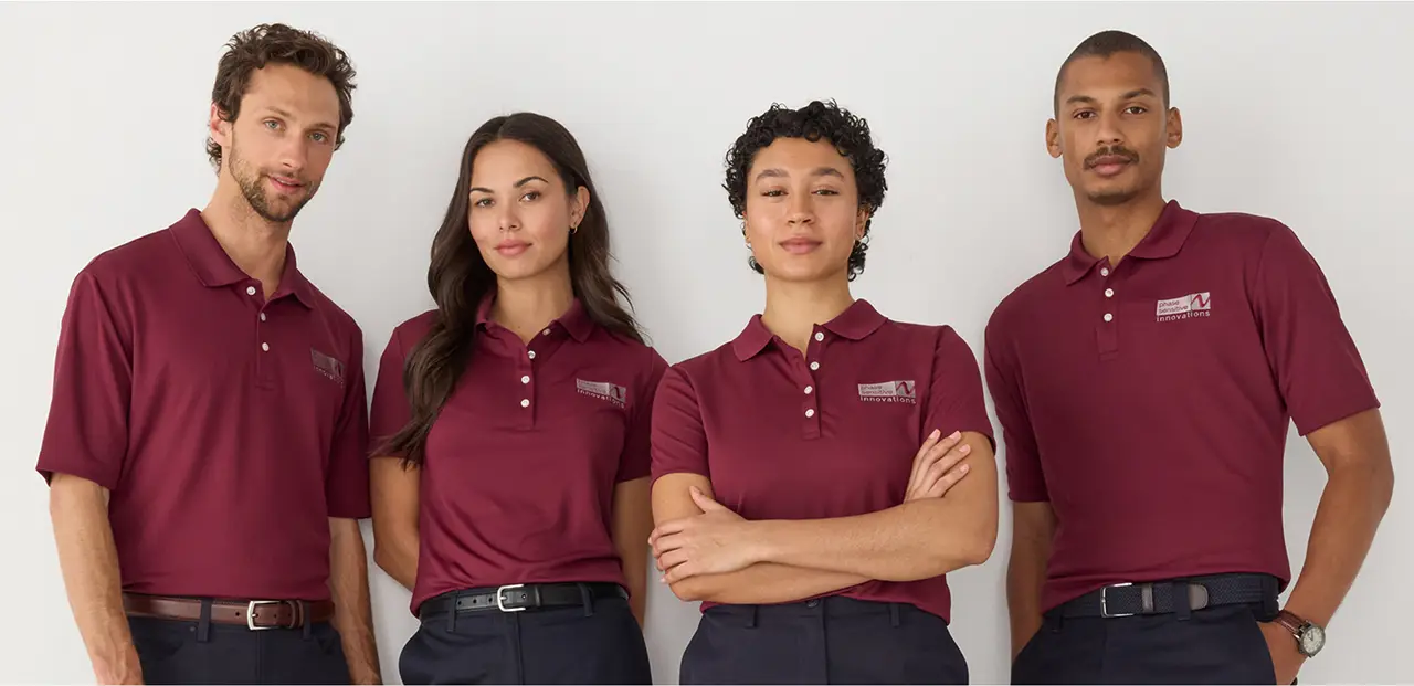 Group of employees wearing a matching uniform of burgundy polos and black pants.