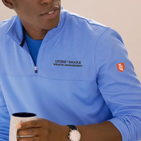 Upper left chest logo placement on a light blue quarter-zip.