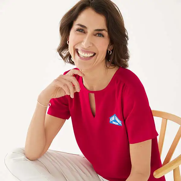 A woman wearing a red heyhole blouse.