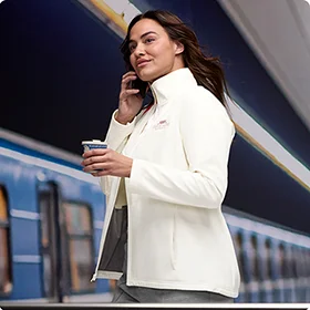 A woman wearing a white soft shell jacket.